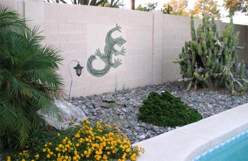 Fence with a stone mosaic lizard.